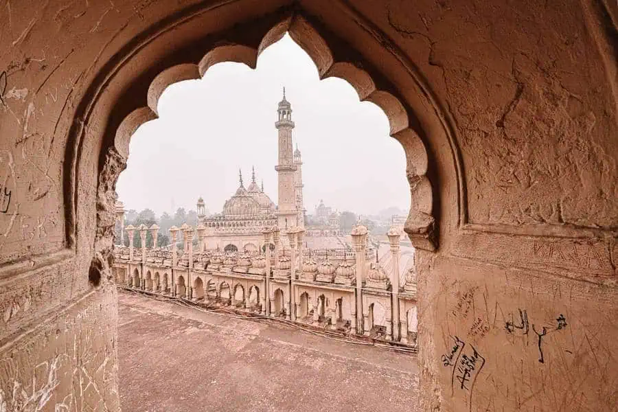 asafi mosque framed through an arched window inside bara imambara, lucknow
