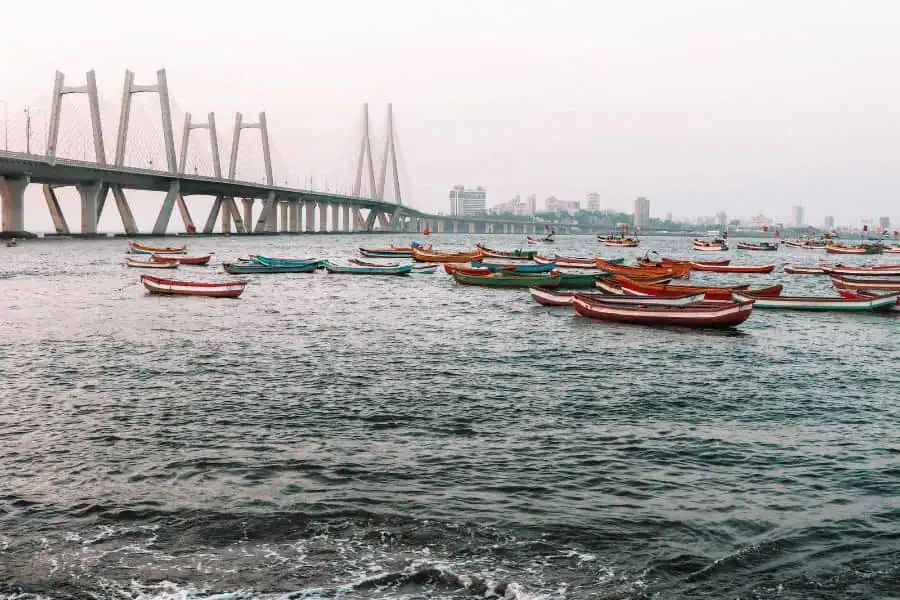 The Bandra-Worli Sea Link viewed from Worli Koliwada fishing village in Mumbai, with traditional Koli fishing boats anchored in the foreground