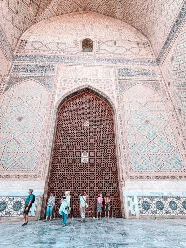 bibi khanym mosque interior iwan with carved wooden lattice and visitors