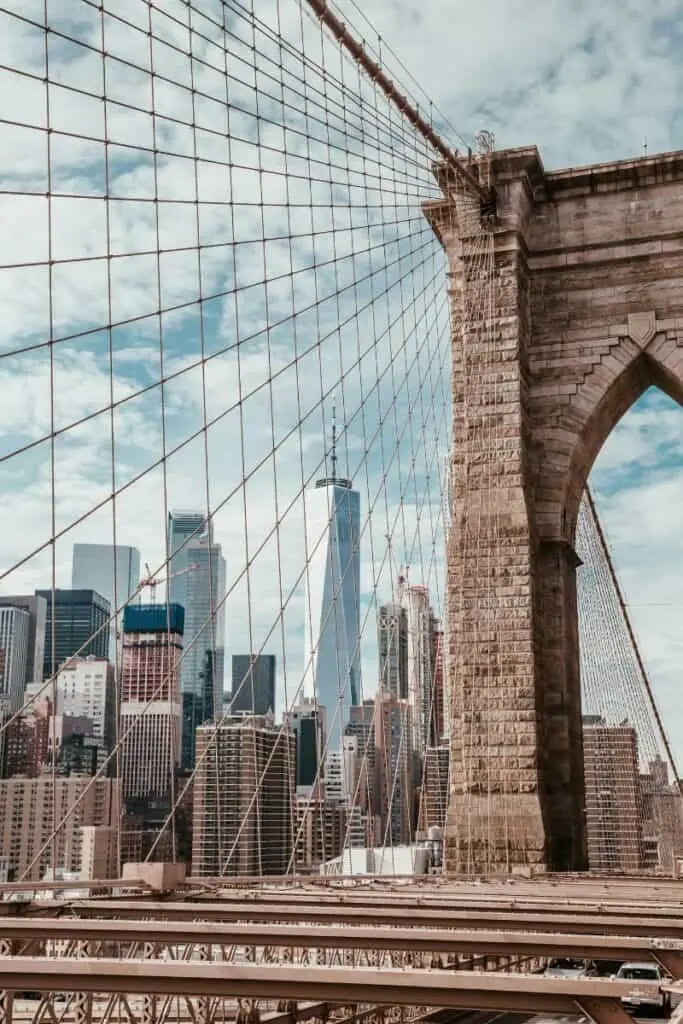  brooklyn bridge with view of one world trade center and new york city skyline