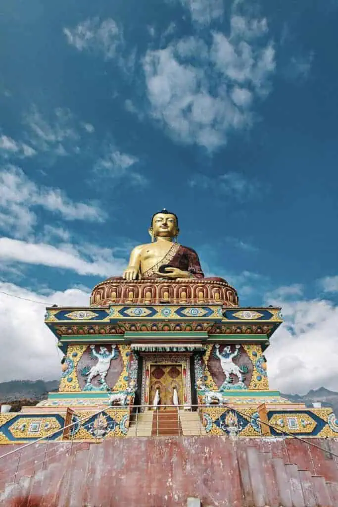 colorful buddha statue at tawang monastery in arunachal pradesh under blue sky