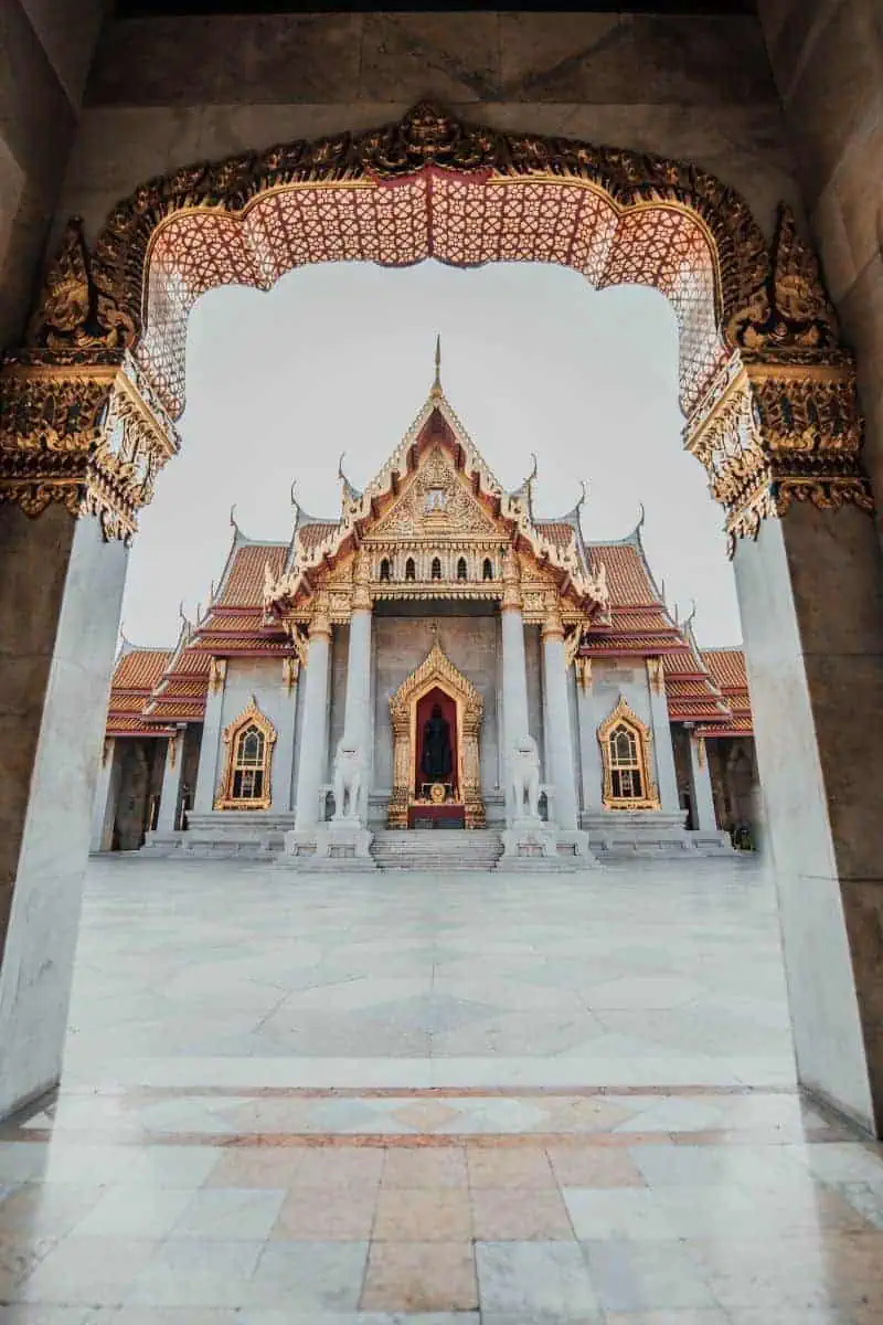 ornate marble temple with golden details and red rooftops in bangkok thailand