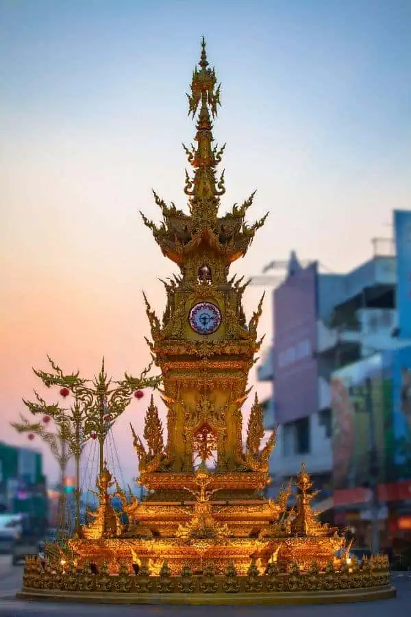 golden chiang rai clock tower at dusk
