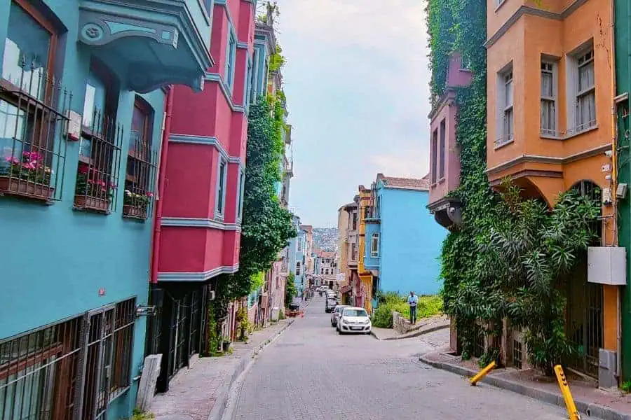 a street in Istanbul's fener-balat neighborhood lined with colorful, ivy-covered houses
