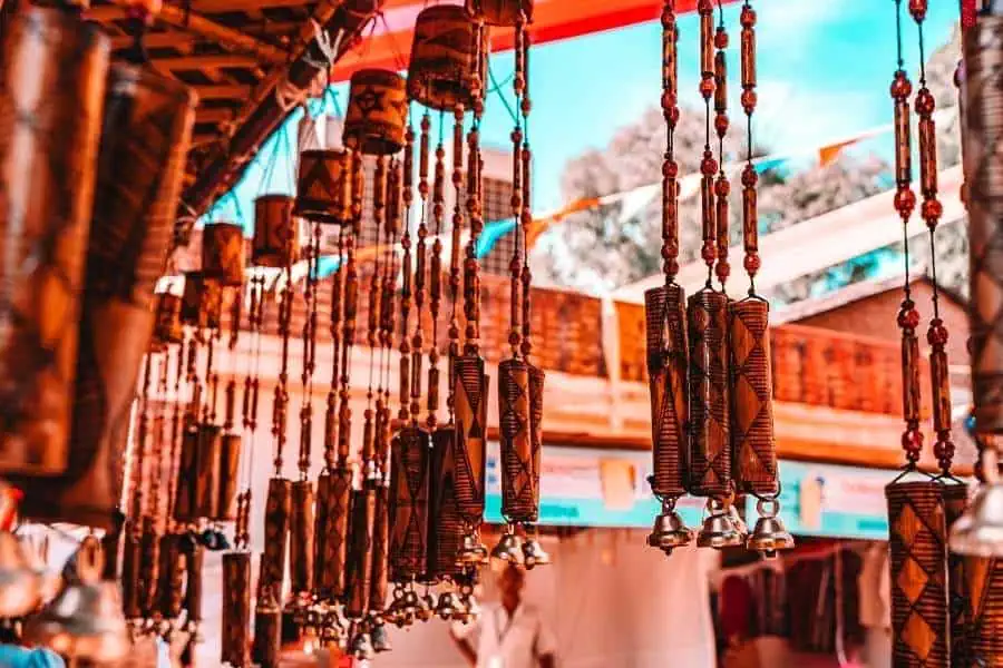 hanging bamboo wind chimes at a handicrafts stall in dilli haat under a vibrant sky