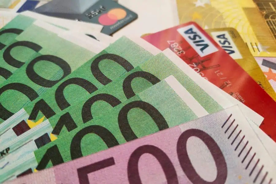 Euro banknotes and international credit cards including Visa and Mastercard placed together on a surface
