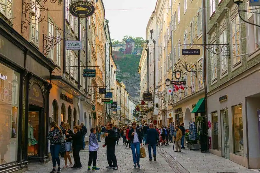 people walking a beautiful historic street in salzburg called getreidegasse