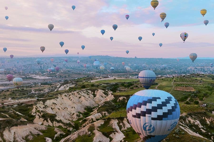 hot air balloons filling the sky at the time of sunrise creating a beautiful scene over cappadocian valley