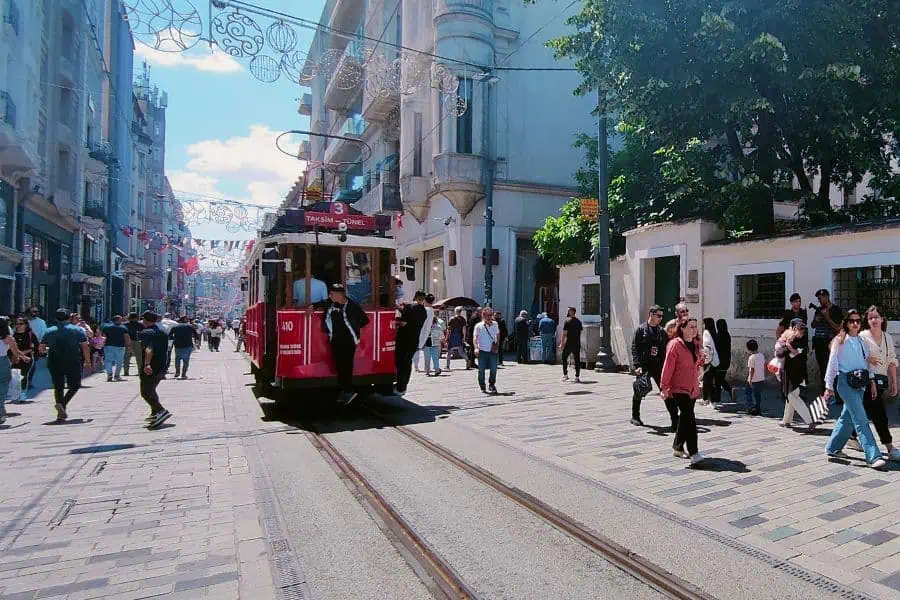 a red tram on istiklal street in istanbul with people walking along the lively street