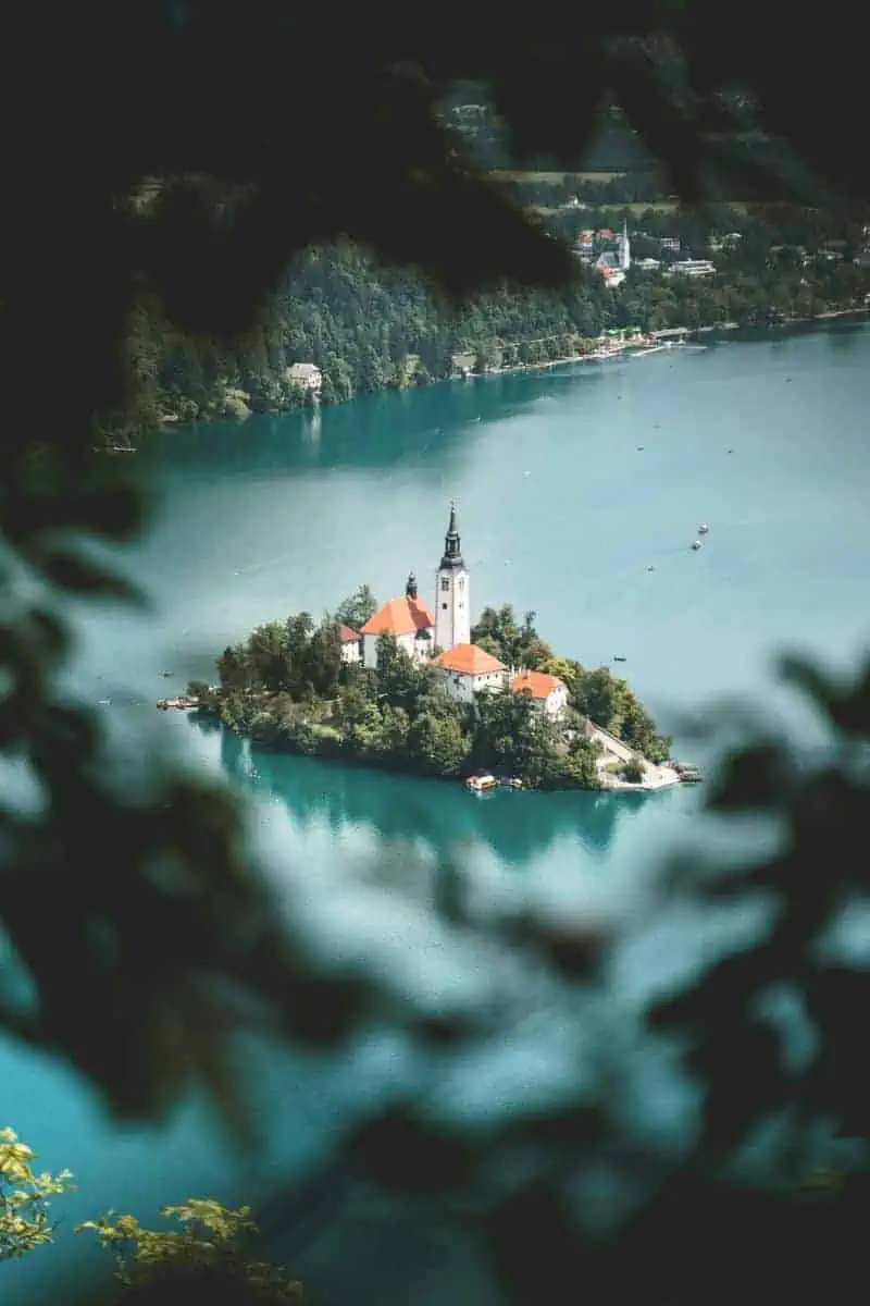 hurch on the island of lake bled surrounded by turquoise water and lush forests in slovenia