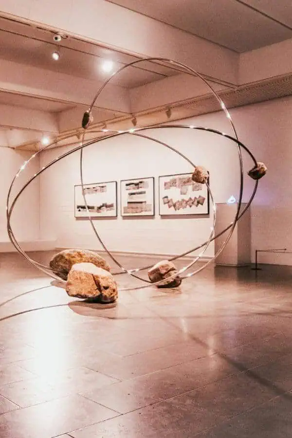 A large metal ring sculpture with suspended rocks in a contemporary art gallery — from Louisiana museum of modern art humlebaek