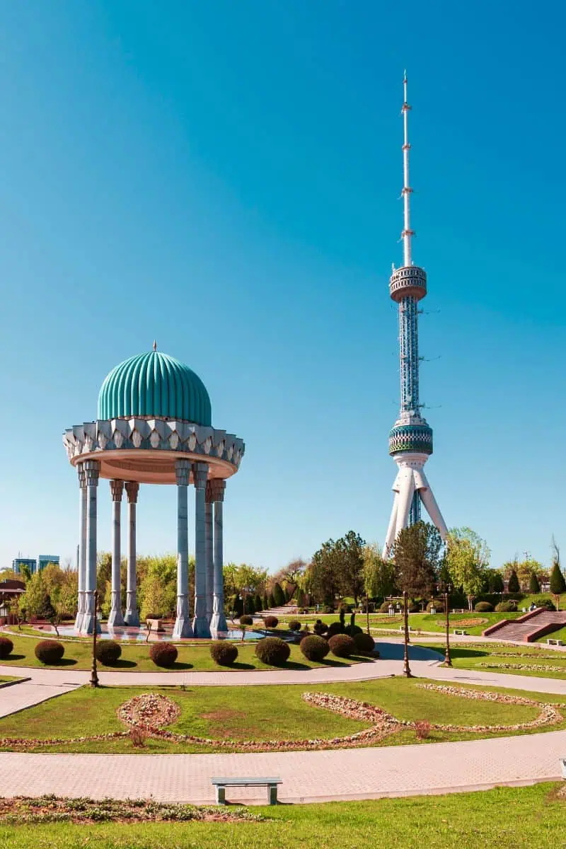memorial of the victims of repression with the blue-domed rotunda and tashkent tv tower in the background under a clear blue sky