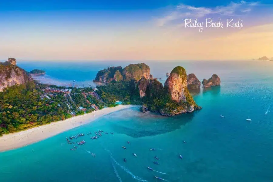 stunning aerial view of railay beach in krabi, thailand, showcasing turquoise waters, limestone cliffs, and sandy shores at sunset