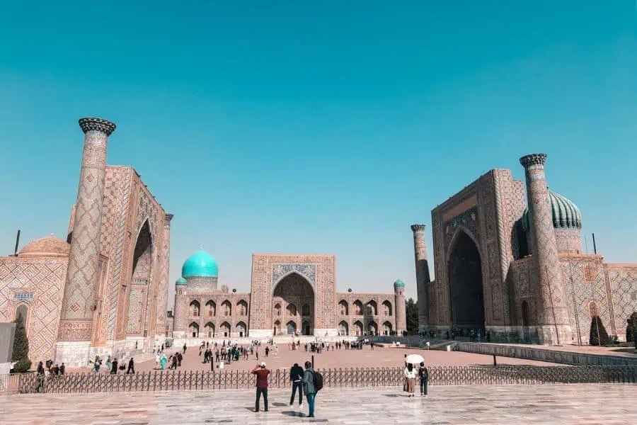 wide view of registan square in samarkand showing all three madrasahs and visitors