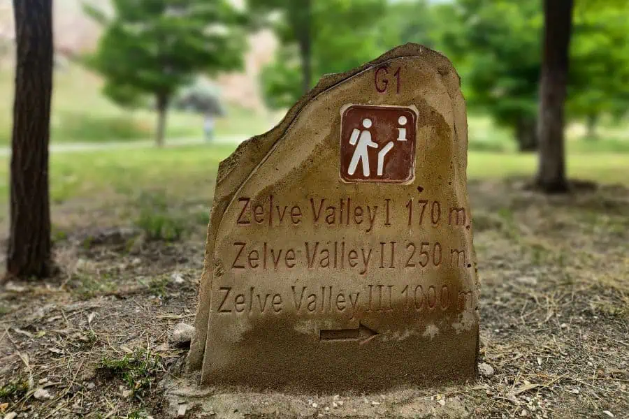 a stone plaque shows directions to the three valleys in the zelve open air museum