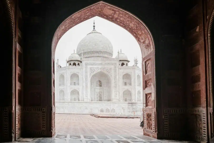 taj mahal viewed through an arched gateway at agra