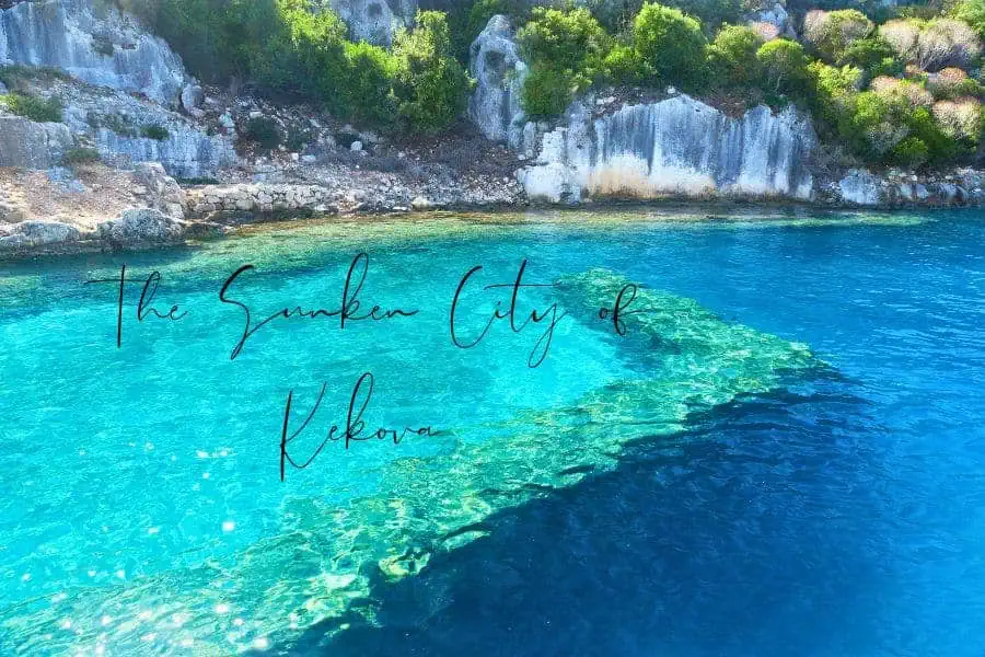 crystal-clear turquoise waters revealing the sunken ruins of the ancient city of kekova, turkey, with lush green hills and rocky cliffs in the background