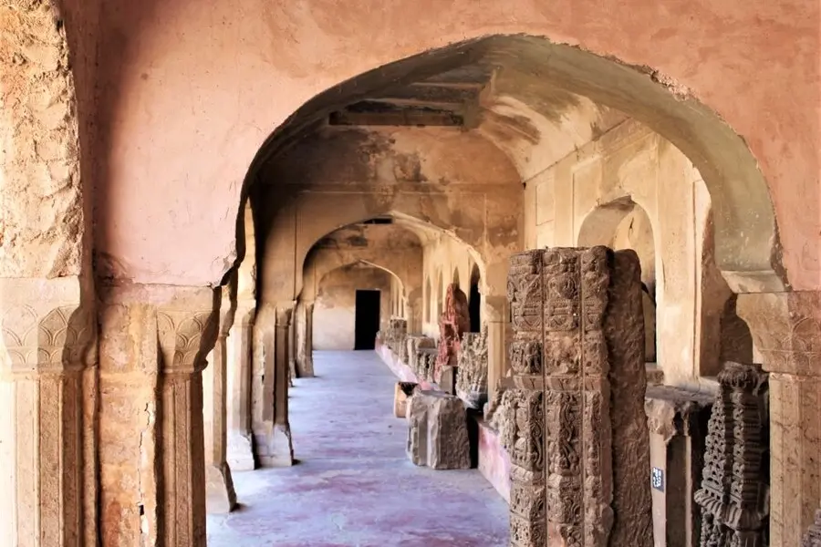 ancient stone sculptures in a corridor around chand baori step well