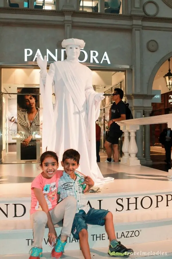 kids posing with a living statue at the venetain las vegas