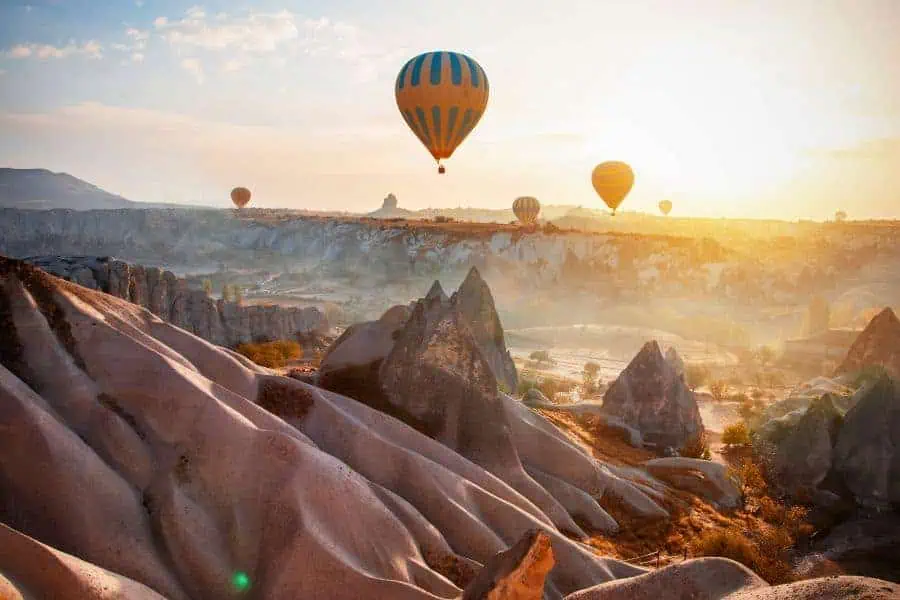 hot air balloons flying above unique rock formations fairy chimneys in cappadocia