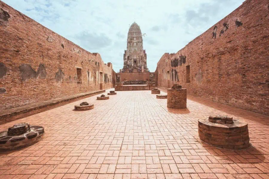 ancient ruins of wat ratchaburana in ayutthaya, thailand, featuring a towering prang framed by weathered brick walls and remnants of the former temple structure